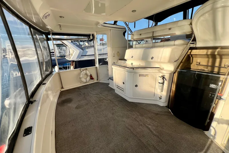 Slide: The Image of 1997 Sea Ray 370 Aft Cabin interior with seating and storage, docked at marina. - 9