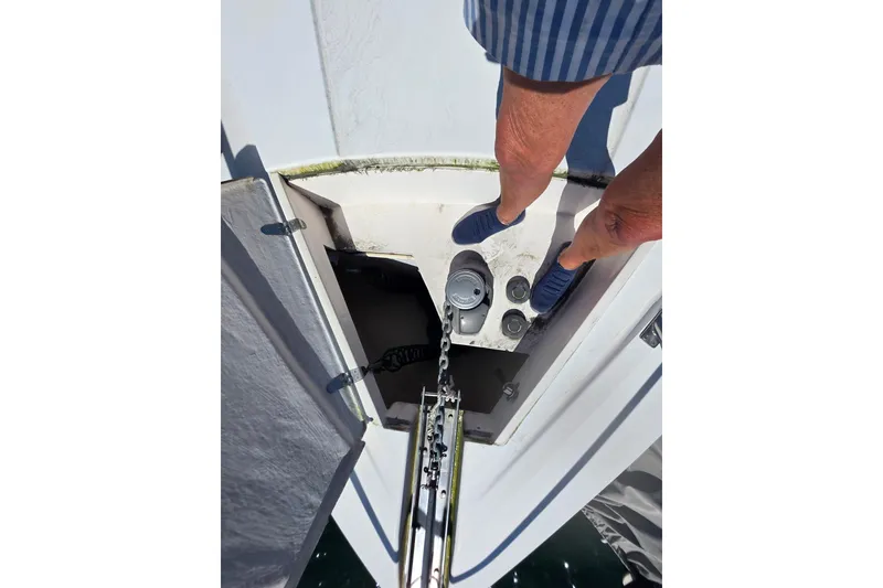 Slide: The Image of Man standing on Neptunus 56 Express yacht, inspecting anchor chain mechanism. - 15