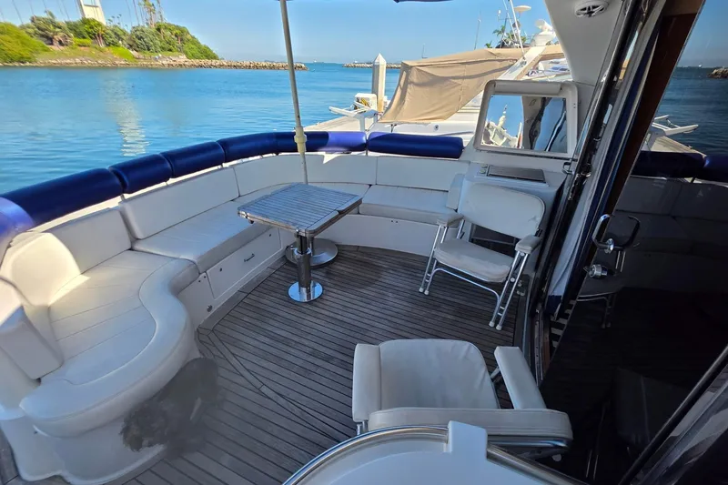 Slide: The Image of Luxurious 2000 Neptunus 56 Express yacht deck with seating and table, overlooking serene waters. - 16