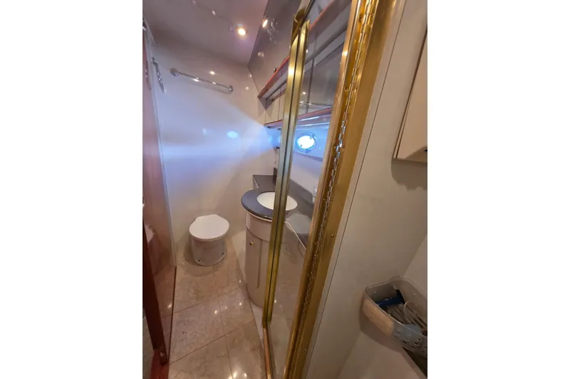 Slide: The Image of Bathroom interior of 2000 Neptunus 56 Express yacht with gold accents and porthole window. - 18