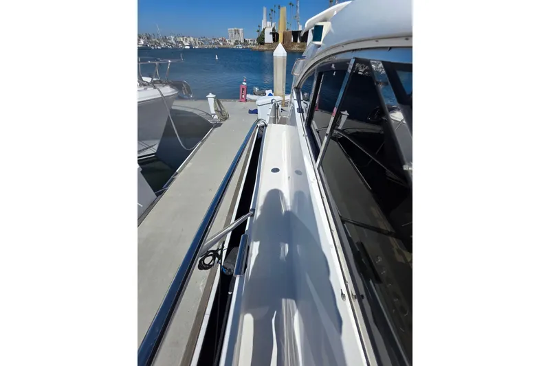 Slide: The Image of 2000 Neptunus 56 Express yacht docked at marina under clear blue sky. - 5