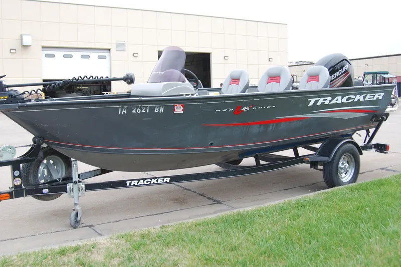 Slide: The Image of 2015 Tracker Pro Guide V-16 SC boat on trailer, parked outside a building. - 2