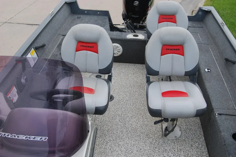Slide: The Image of 2015 Tracker Pro Guide V-16 SC boat interior with three gray and red seats. - 7