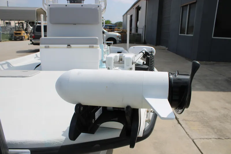 Slide: The Image of 2023 Shoalwater 19' Catamaran with mounted trolling motor in a boatyard setting. - 14