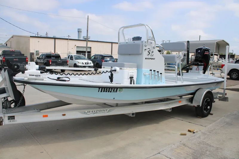 Slide: The Image of 2023 Shoalwater 19' Catamaran on trailer, parked outdoors, featuring Minn Kota trolling motor. - 2