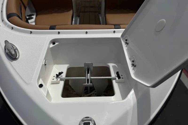 Slide: The Image of 2024 Chaparral 247 SSX boat anchor compartment with open hatch, showcasing storage space. - 13