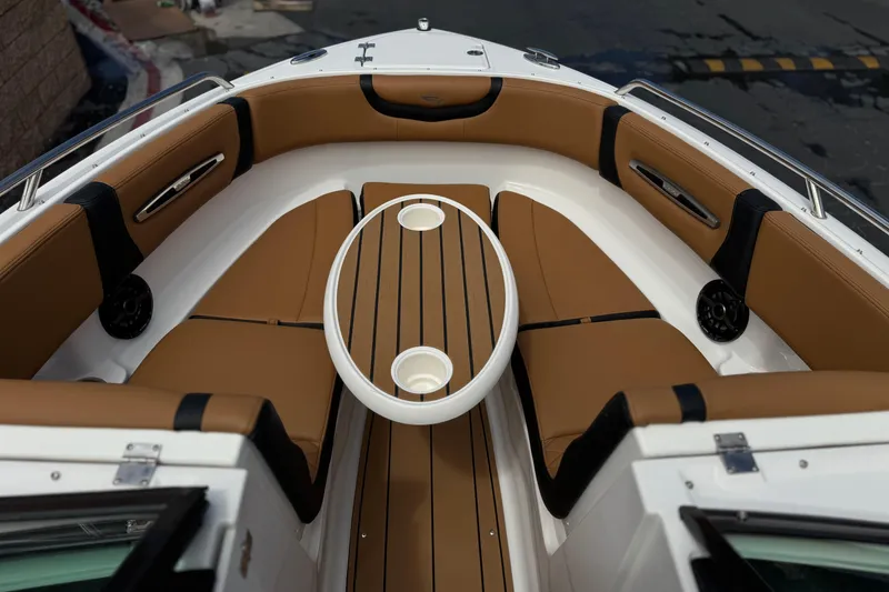 Slide: The Image of 2024 Chaparral 247 SSX boat interior with tan seating and wooden table. - 14