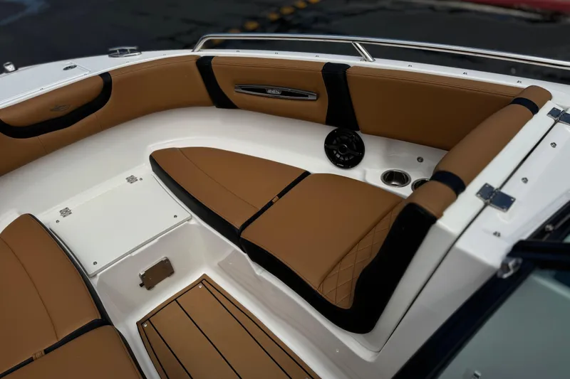 Slide: The Image of 2024 Chaparral 247 SSX boat interior with tan and black seating, cup holders, and speaker. - 18