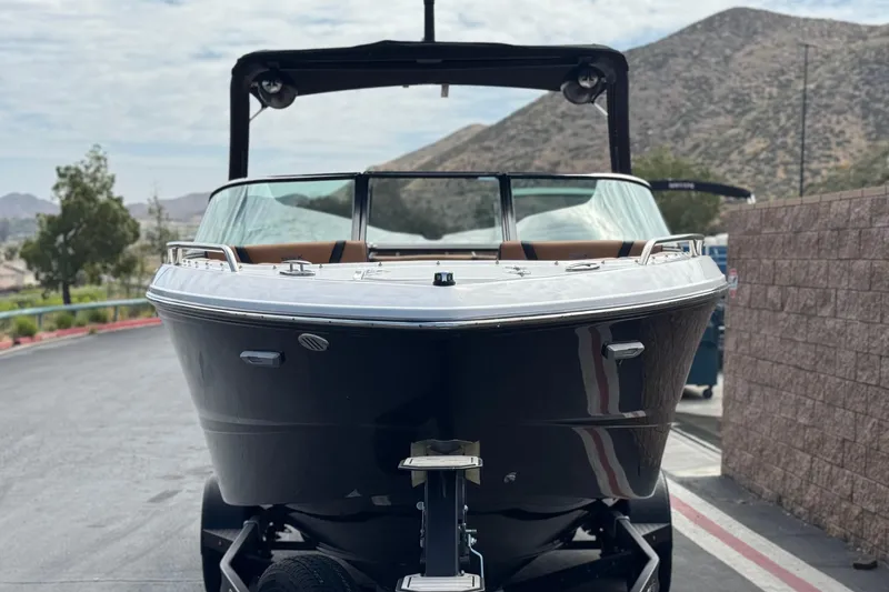 Slide: The Image of 2024 Chaparral 247 SSX boat on trailer, parked with mountainous backdrop. - 2