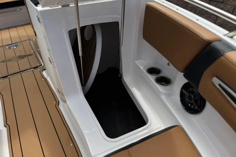 Slide: The Image of 2024 Chaparral 247 SSX boat interior with tan seating, cup holders, and speaker. - 21