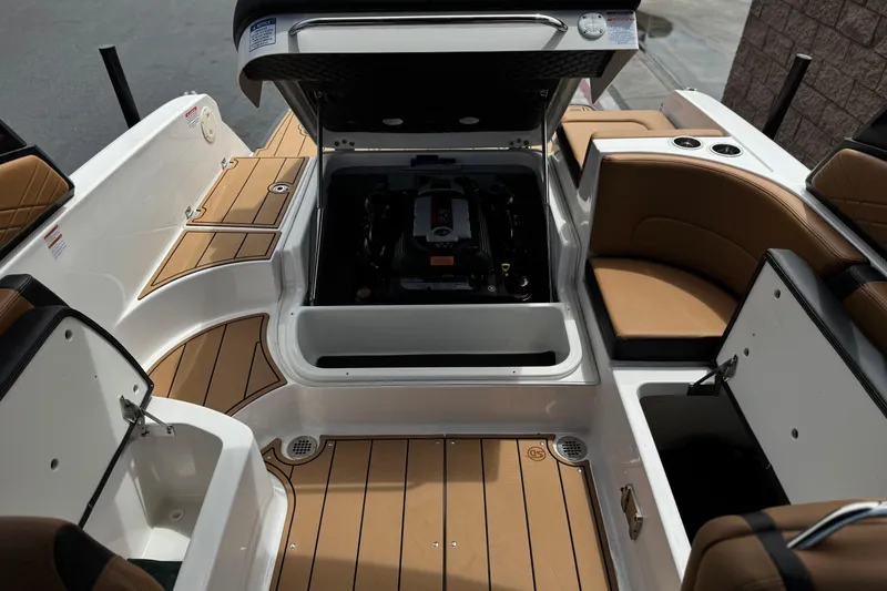 Slide: The Image of 2024 Chaparral 247 SSX boat interior with open engine compartment and tan seating. - 26