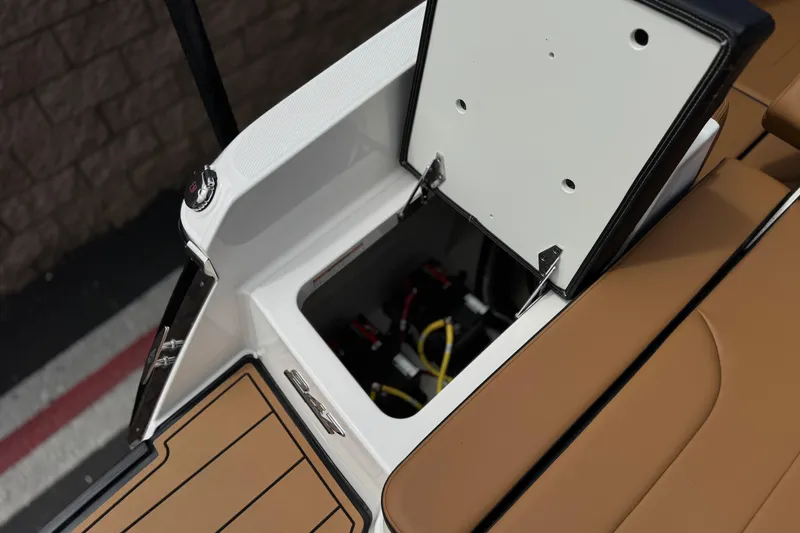 Slide: The Image of 2024 Chaparral 247 SSX boat storage compartment with open hatch and visible wiring. - 29