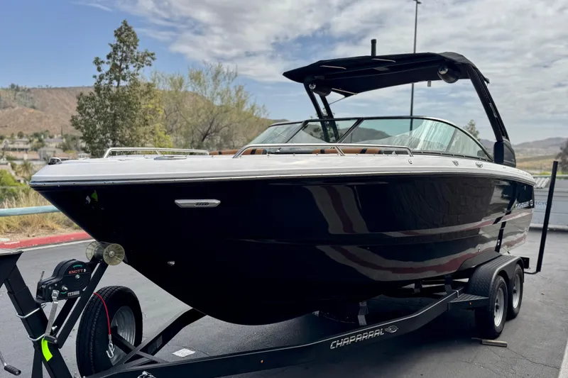 Slide: The Image of 2024 Chaparral 247 SSX boat on trailer, parked outdoors under cloudy sky. - 3