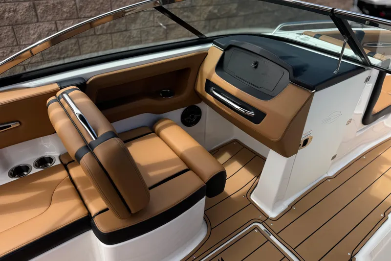 Slide: The Image of 2024 Chaparral 247 SSX boat interior with tan seating and sleek dashboard design. - 31