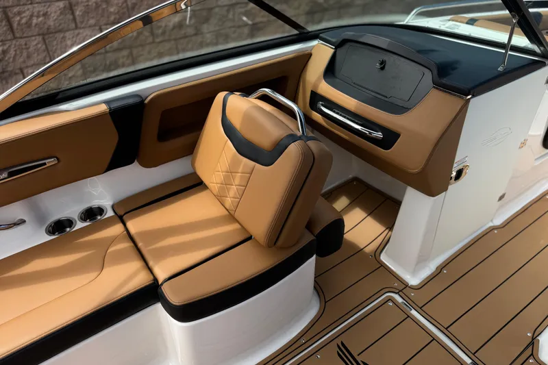 Slide: The Image of 2024 Chaparral 247 SSX boat interior with tan leather seating and sleek dashboard design. - 32
