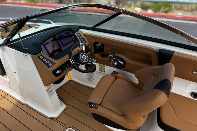 Slide: The Image of 2024 Chaparral 247 SSX boat interior with modern dashboard and tan seating. - 33