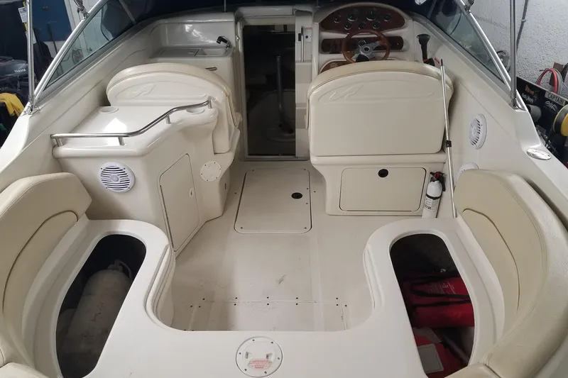 Slide: The Image of 2001 Sea Ray 260 Overnighter boat interior with beige seating and dashboard. - 4