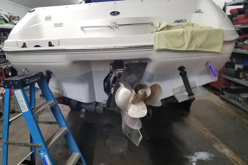 Slide: The Image of 2001 Sea Ray 260 Overnighter boat in garage, ladder nearby, propeller visible. - 8