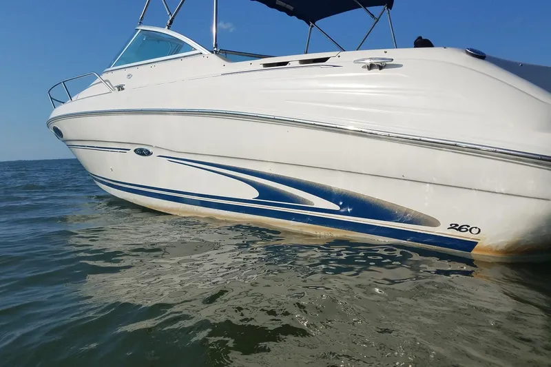 Slide: The Image of 2001 Sea Ray 260 Overnighter boat on calm water, featuring sleek design and blue accents. - 9
