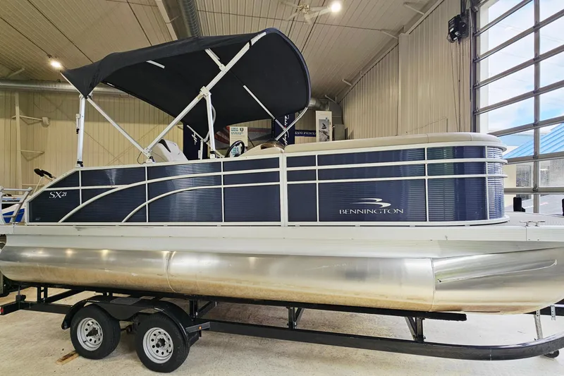 The Image of 2019 Bennington 21 SX Swingback pontoon boat with canopy in indoor showroom. - 1