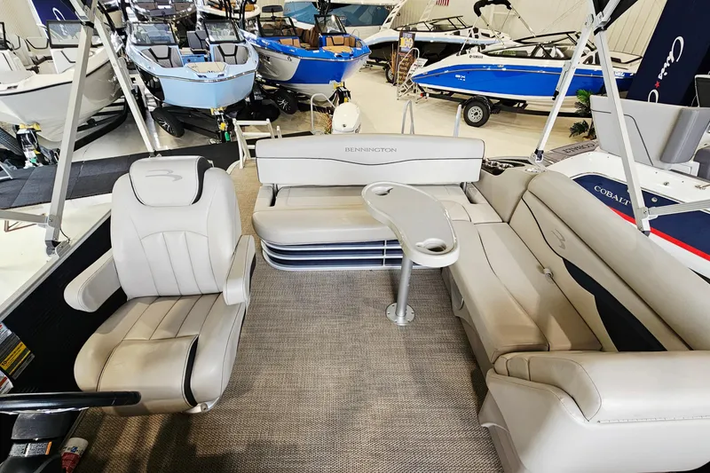 Slide: The Image of 2019 Bennington 21 SX Swingback pontoon boat interior with beige seating and table. - 7