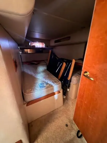 Slide: The Image of Interior of a 2001 Cruisers Yachts 3870 with bed and wooden door. - 11