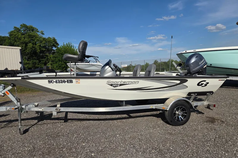 The Image of 2022 G3 Sportsman 1610 boat on trailer, parked outdoors under clear blue sky. - 0