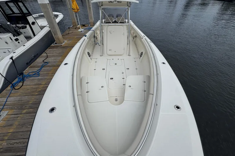 Slide: The Image of 2006 Pursuit 3480 Center Console boat docked, showcasing spacious deck and sleek design. - 10