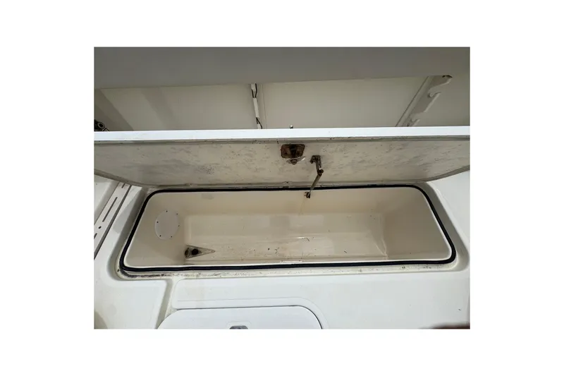 Slide: The Image of Open storage compartment on a 2006 Pursuit 3480 Center Console boat. - 18