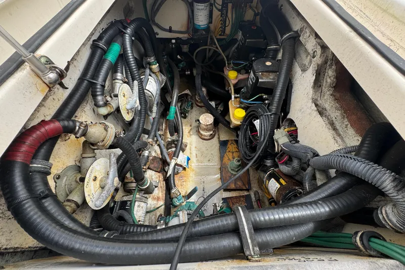 Slide: The Image of Engine compartment of a 2006 Pursuit 3480 Center Console boat with visible hoses and components. - 20