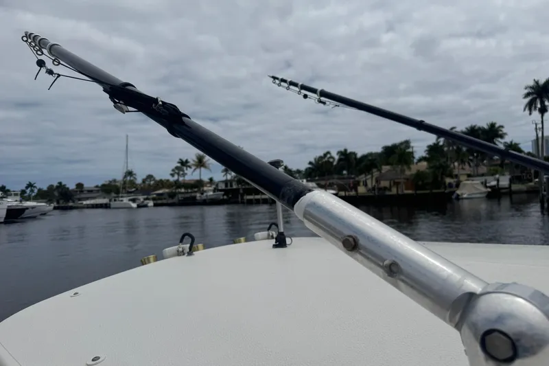 Slide: The Image of Fishing rods on a 2006 Pursuit 3480 Center Console boat, docked near palm trees. - 22