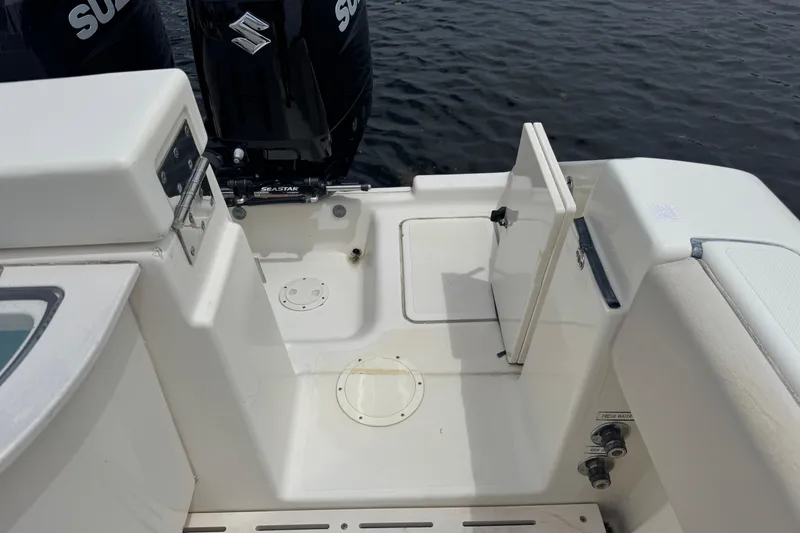 Slide: The Image of 2006 Pursuit 3480 Center Console boat deck with Suzuki engines and open hatch. - 24