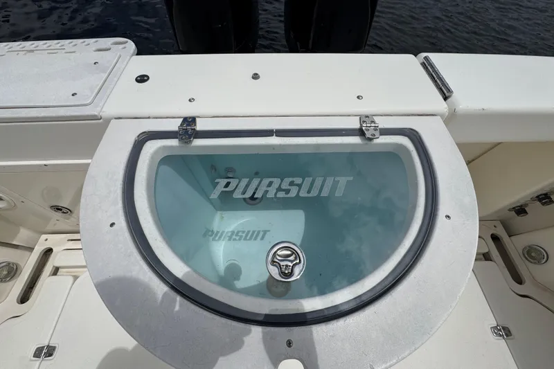 Slide: The Image of 2006 Pursuit 3480 Center Console boat livewell with logo, open water background. - 25