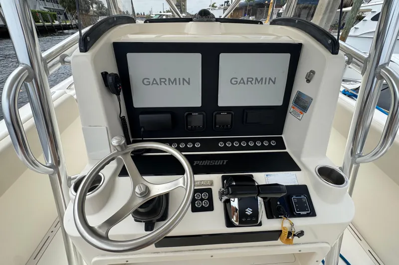 Slide: The Image of 2006 Pursuit 3480 Center Console boat dashboard with Garmin navigation displays and steering wheel. - 6
