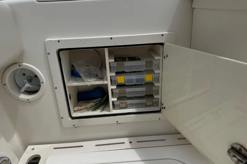 Slide: The Image of Storage compartment on a 2006 Pursuit 3480 Center Console boat with organized tackle boxes. - 8