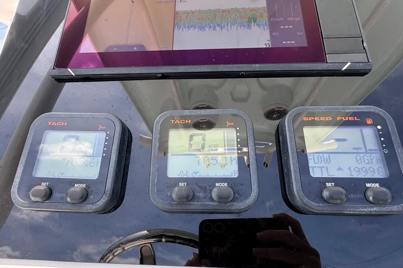 Slide: The Image of Dashboard of a 2014 Tidewater 250 CC Adventure boat with tachometer and speed fuel gauges. - 13