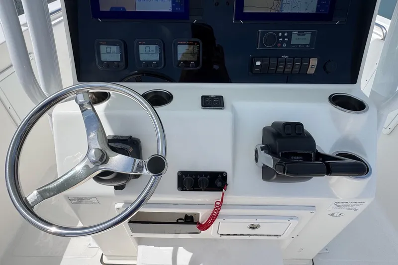 Slide: The Image of Steering console of 2014 Tidewater 250 CC Adventure boat with navigation controls. - 18