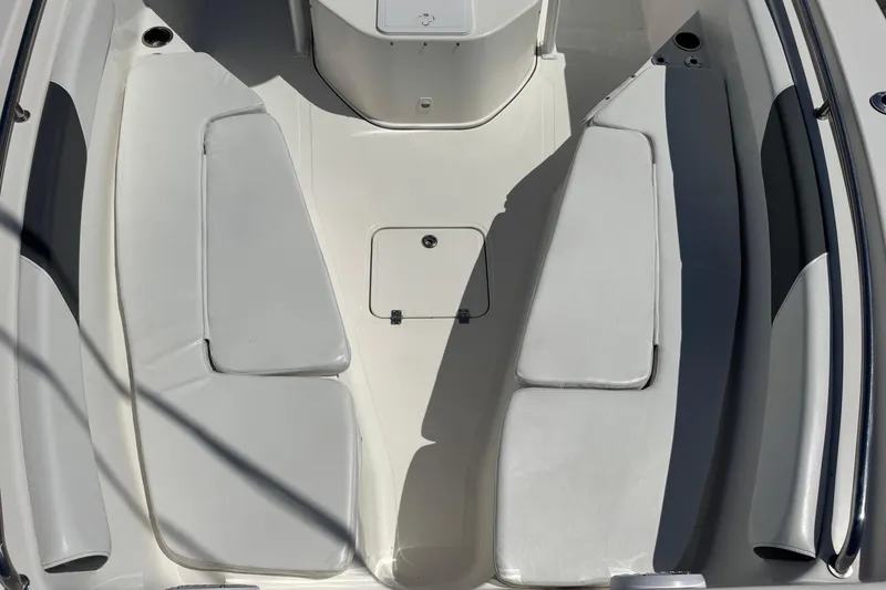 Slide: The Image of 2014 Tidewater 250 CC Adventure boat interior with cushioned seating and storage compartment. - 26