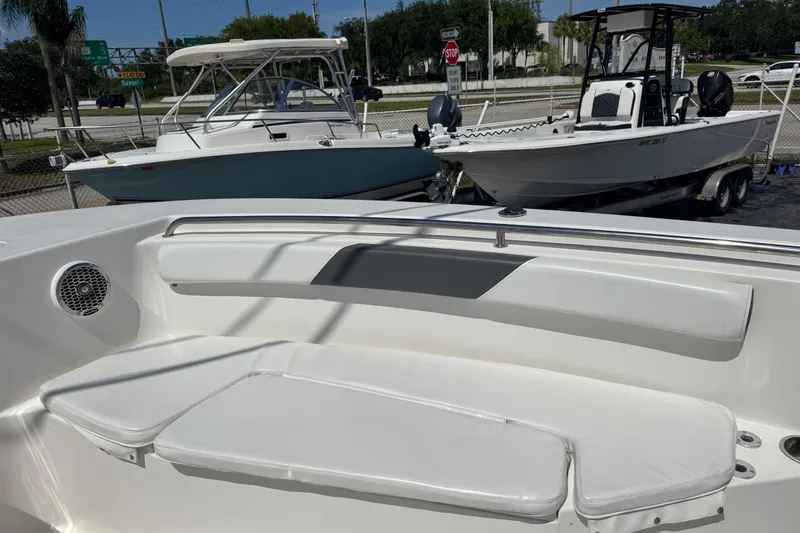 Slide: The Image of 2014 Tidewater 250 CC Adventure boat interior with seating, parked alongside other boats. - 28