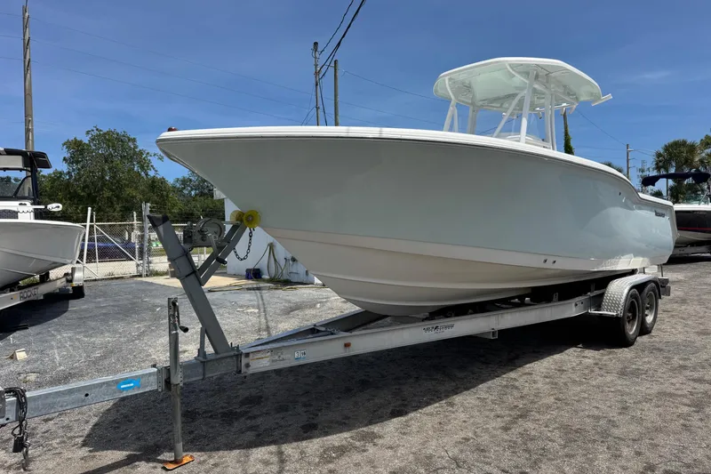 Slide: The Image of 2014 Tidewater 250 CC Adventure boat on trailer, parked outdoors under clear sky. - 3