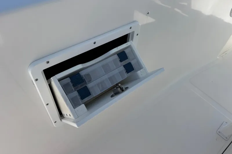 Slide: The Image of Storage compartment on a 2014 Tidewater 250 CC Adventure boat, featuring organized tackle boxes. - 36