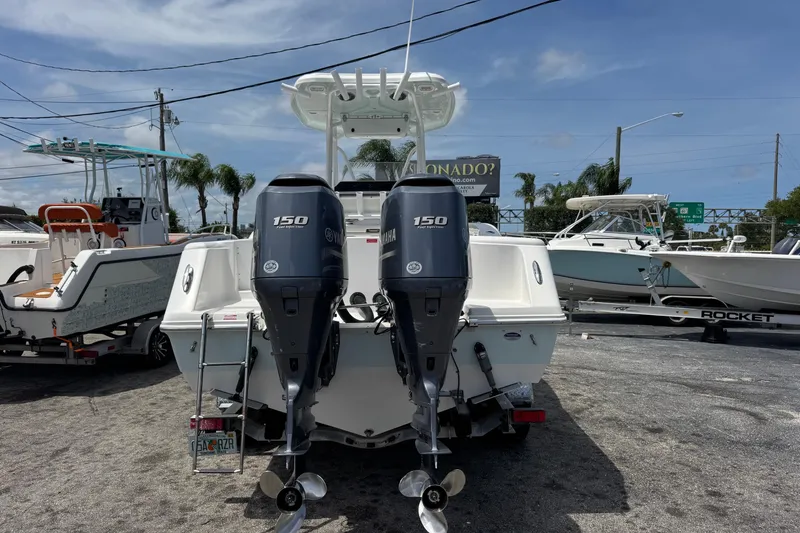 Slide: The Image of 2014 Tidewater 250 CC Adventure boat with dual Yamaha 150 engines, parked outdoors. - 4