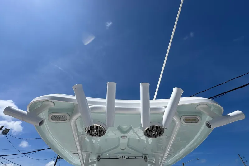 Slide: The Image of 2014 Tidewater 250 CC Adventure boat's rod holders and speakers under a clear blue sky. - 47