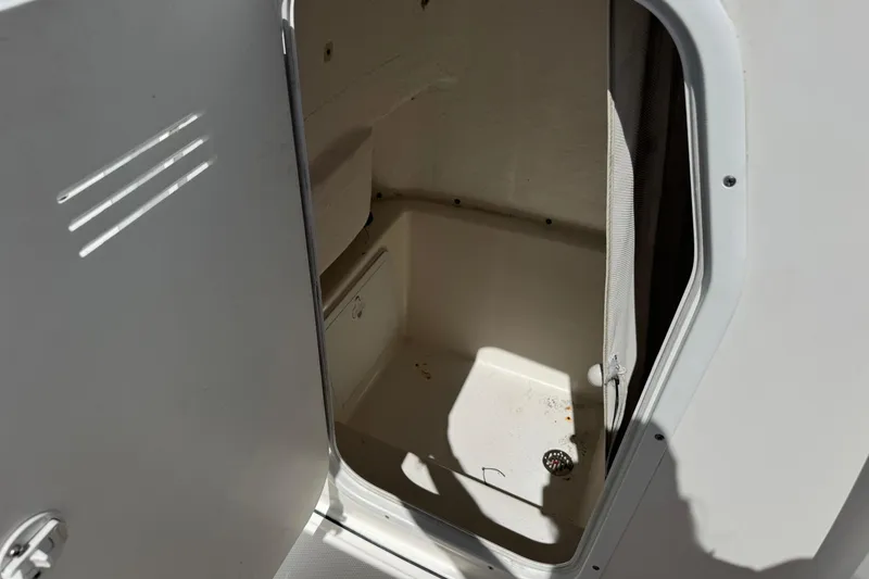 Slide: The Image of 2014 Tidewater 250 CC Adventure boat storage compartment with open door. - 48