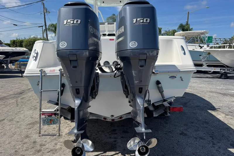 Slide: The Image of 2014 Tidewater 250 CC Adventure boat with dual Yamaha 150 engines, parked outdoors. - 54