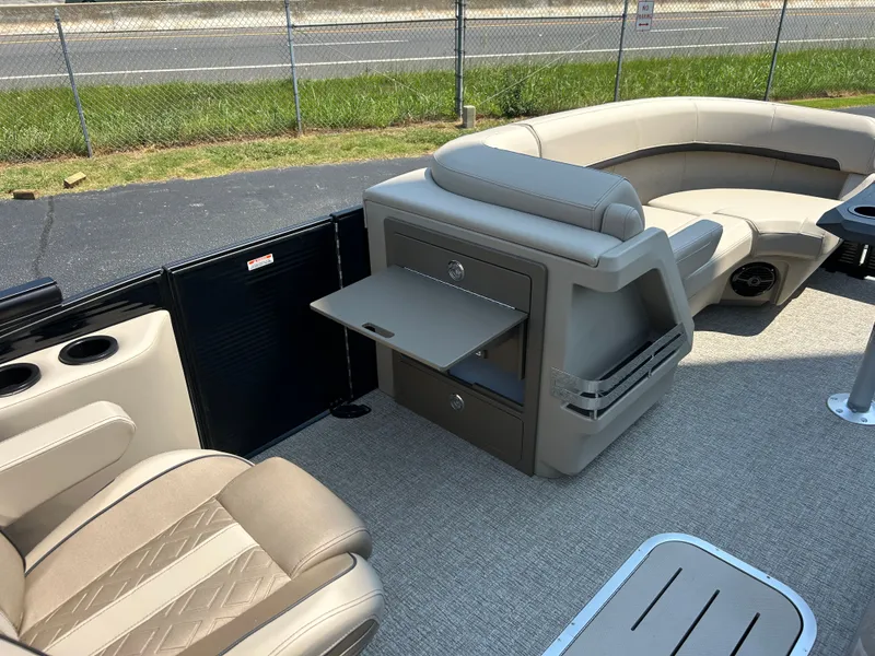 Slide: The Image of The image shows the interior of a Bennington 22 MFB pontoon boat with beige seating and a fold-out table. - 23