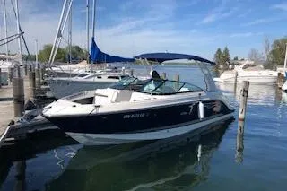 The Image of 2018 Sea Ray SLX 250 boat docked in a marina under a clear blue sky. - 0