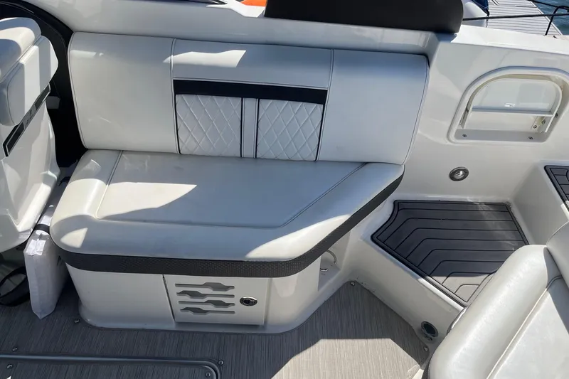 Slide: The Image of 2018 Sea Ray SLX 250 boat interior with white cushioned seating and sleek design. - 13