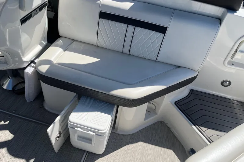 Slide: The Image of 2018 Sea Ray SLX 250 boat interior with cushioned seating and storage compartment. - 14