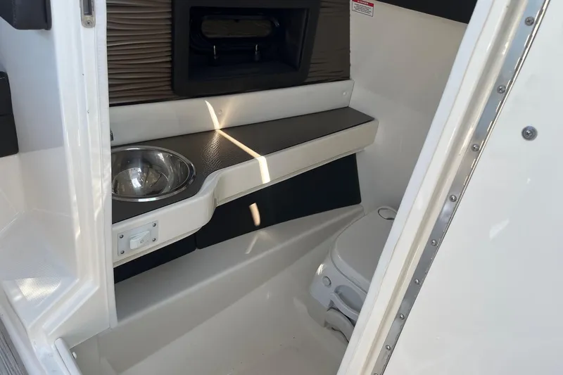 Slide: The Image of Interior of 2018 Sea Ray SLX 250 boat featuring a compact bathroom with sink and toilet. - 19